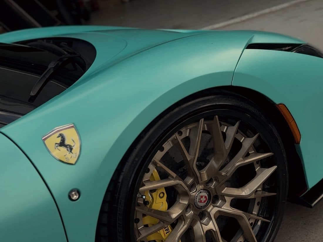 Bronze wheel and mint green flank of a Ferrari F8 Tributo