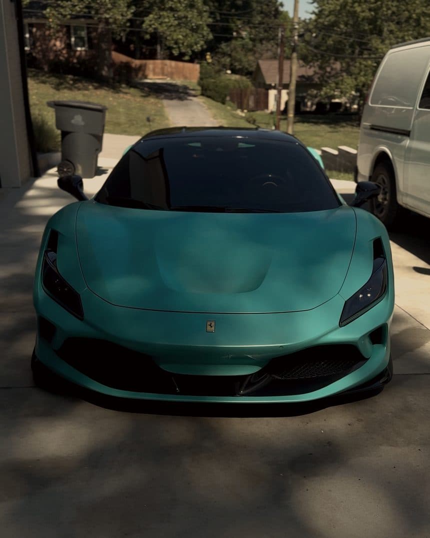 Mint green Ferrari F8 Tributo head on, parked in a driveway