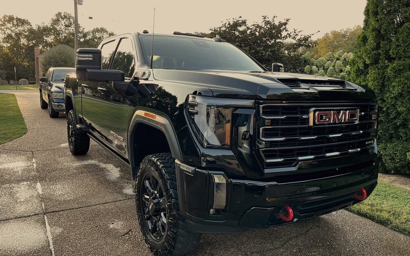 Black GMC pickup truck on a wet driveway