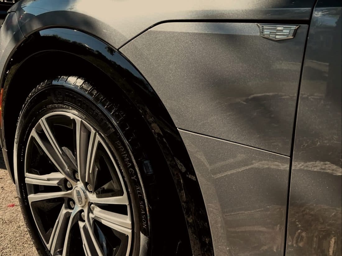 Flank and wheel of a dark grey car
