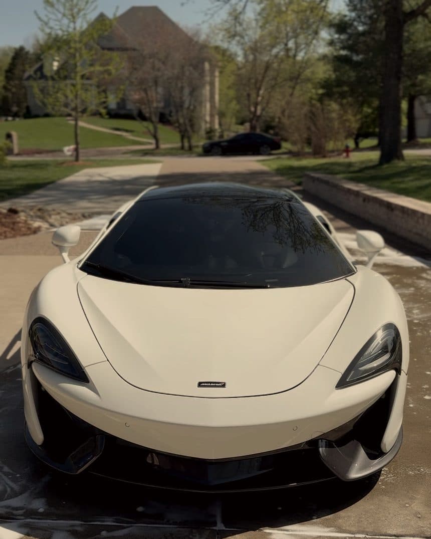 White McLaren 570S head on, on a wet driveway